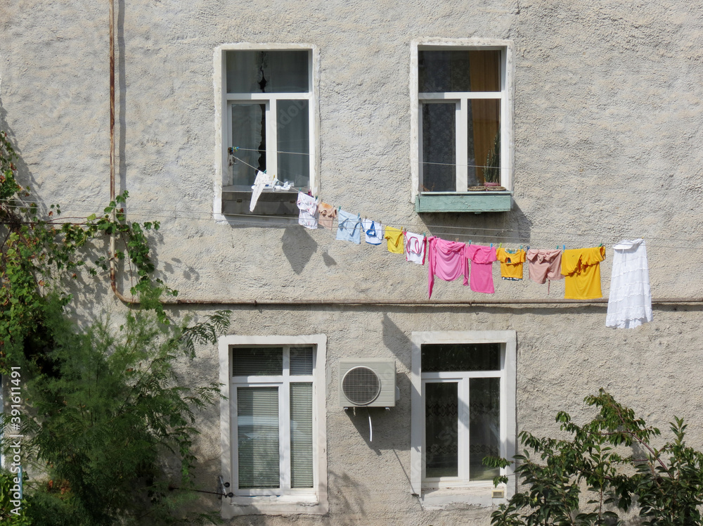 Colored laundry is dried on a rope outside on a hot sunny day.