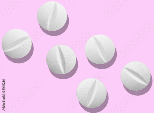 Top view of a group of six  pills on a pink background