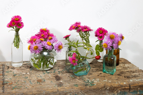 Wallpaper Mural Autumn asters in small pharmacy bottles instead of vases on a long wooden bench Torontodigital.ca