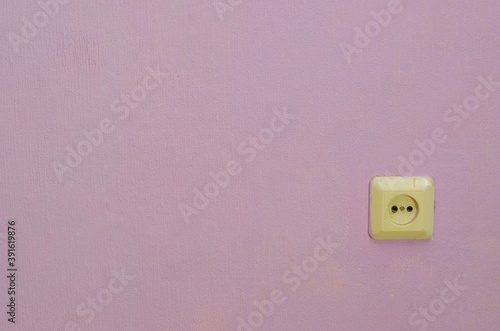 Electrical outlet on the wall, with pink Wallpaper