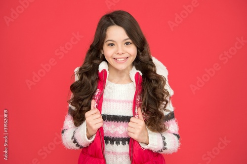 happy teen girl wear warm clothes. winter kid fashion. child with long curly hair in christmas aparrel. cold season activity style. childhood happiness. thermal clothing photo