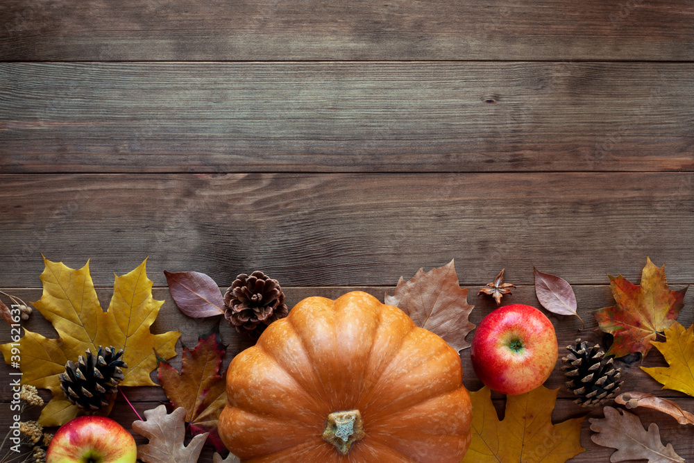 Autumn frame made of ripe orange pumpkin, apples, pine cones and dry fallen leaves on rustic wooden background. Happy Thanksgiving day, fall and harvesting concept. Flat lay, top view, copy space. Autumn frame made of ripe orange pumpkin, apples, pine cones and dry fallen leaves on rustic wooden background. Happy Thanksgiving day, fall and harvesting concept. Flat lay, top view, copy space.