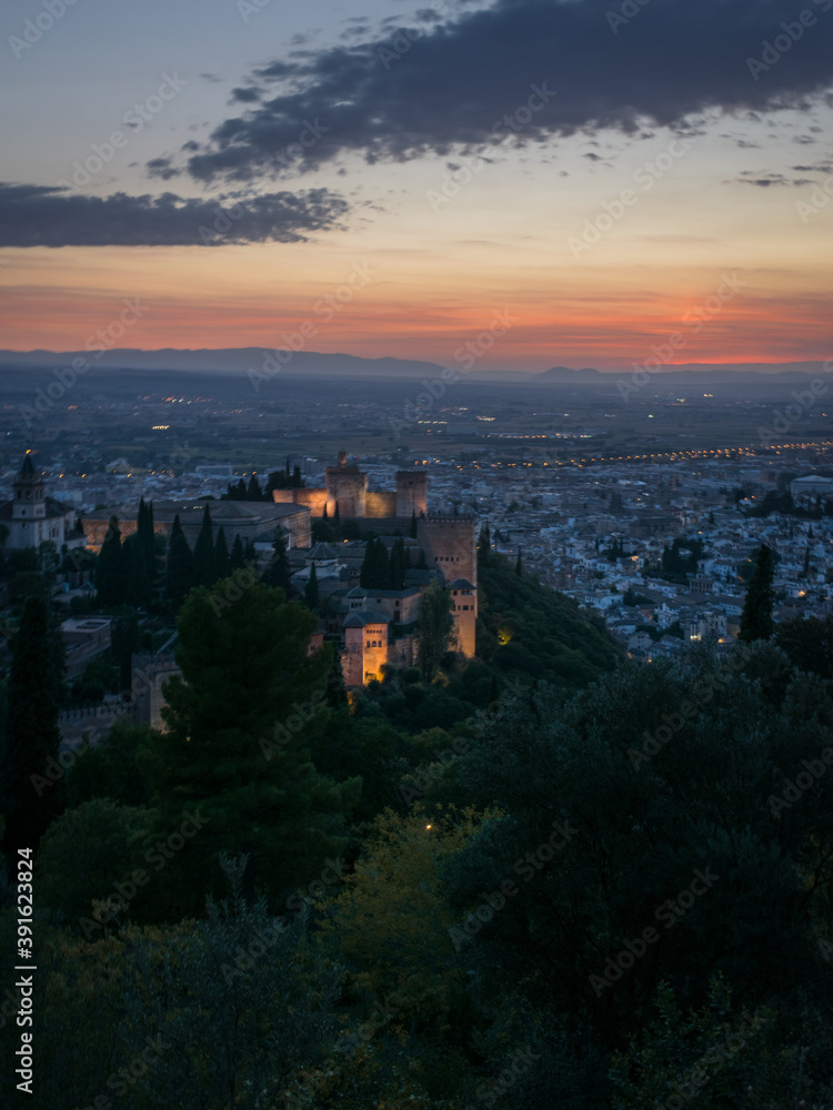 The Alhambra in Granada during a sunset with beautiful views of the city at its best, articulating the landscape with incredible architecture.