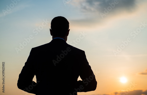 silhouette of man looking far on sunrise sky, future