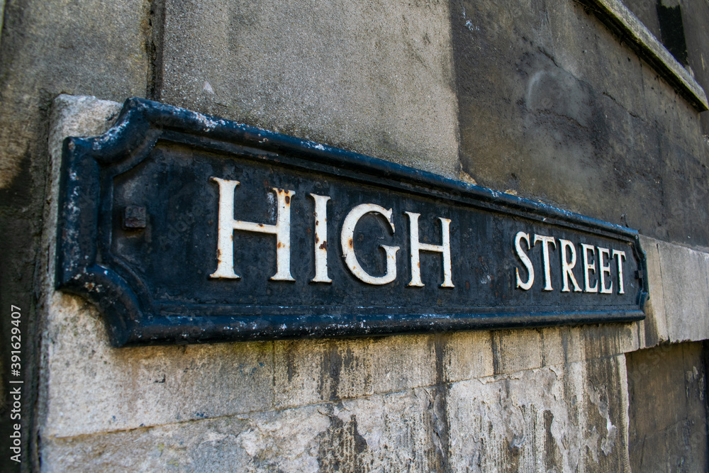 High Street sign in Oxford, black street name paque with white letters, High Streets are often considered to be the most expensive street in the city, with many designer shops and posh restaurants.