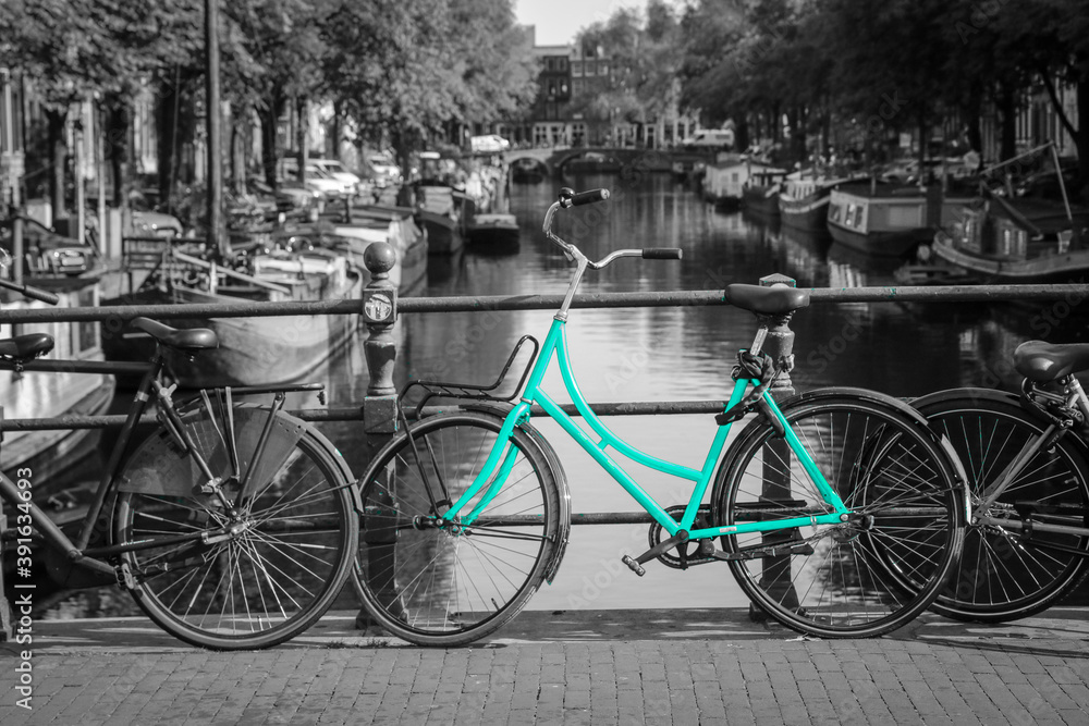 An azure bike on the streets of Amsterdam. Symbol for clean and ecological urban transport. Isolated in a black and white background. 