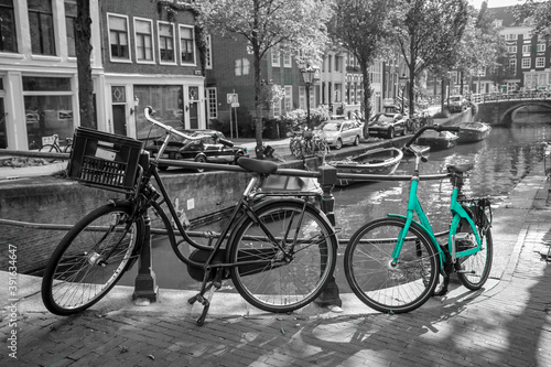 An azure bike on the streets of Amsterdam. Symbol for clean and ecological urban transport. Isolated in a black and white background. © shootingtheworld