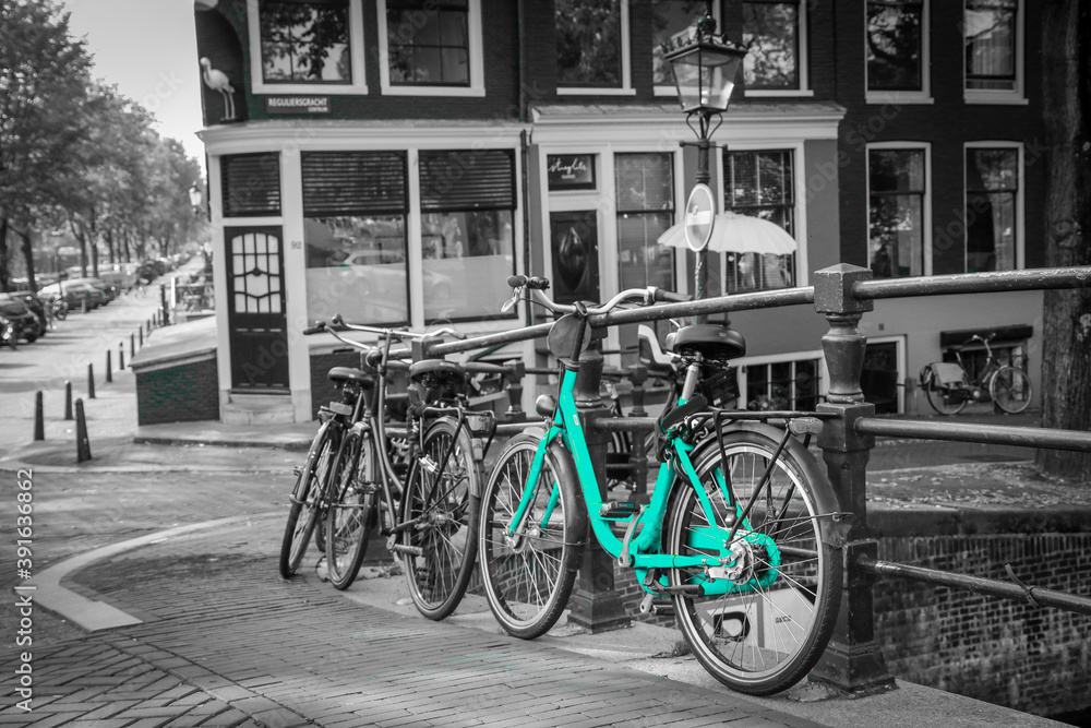 An azure bike on the streets of Amsterdam. Symbol for clean and ecological urban transport. Isolated in a black and white background. 