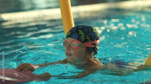Future champion. Swimming training for the little champion. Little cute boy strengthens his health by swimming in the pool.