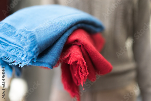 close up of colorful scarf, Close up blue and red cashmere textile clothes, woollen piece of fabric,  soft focus, blurred bokeh on a grey background © Lesia Povkh