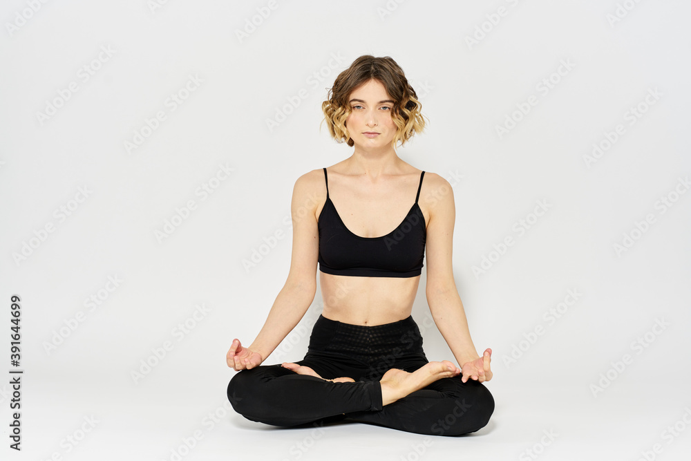 woman in dark clothes sitting on the floor and meditation exercises for legs leggings