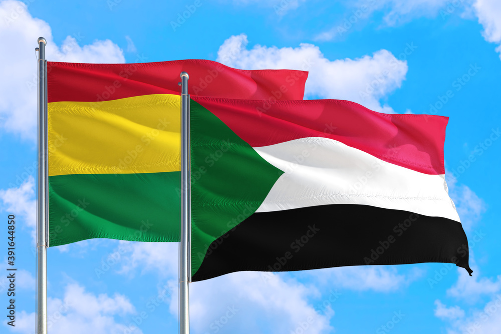 Sudan and Bolivia national flag waving in the windy deep blue sky. Diplomacy and international relations concept. Sudan and Bolivia national flag waving in the windy deep blue sky. Diplomacy and international relations concept.