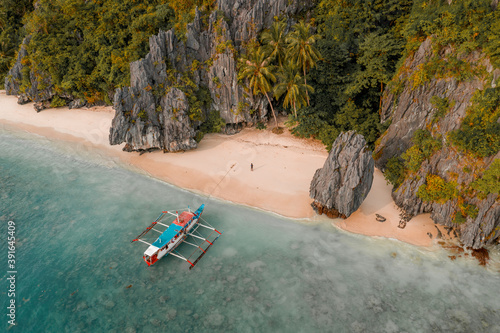 Aerial view of outrigger fishing boat on sandy beach, El Nido, the Philippines.