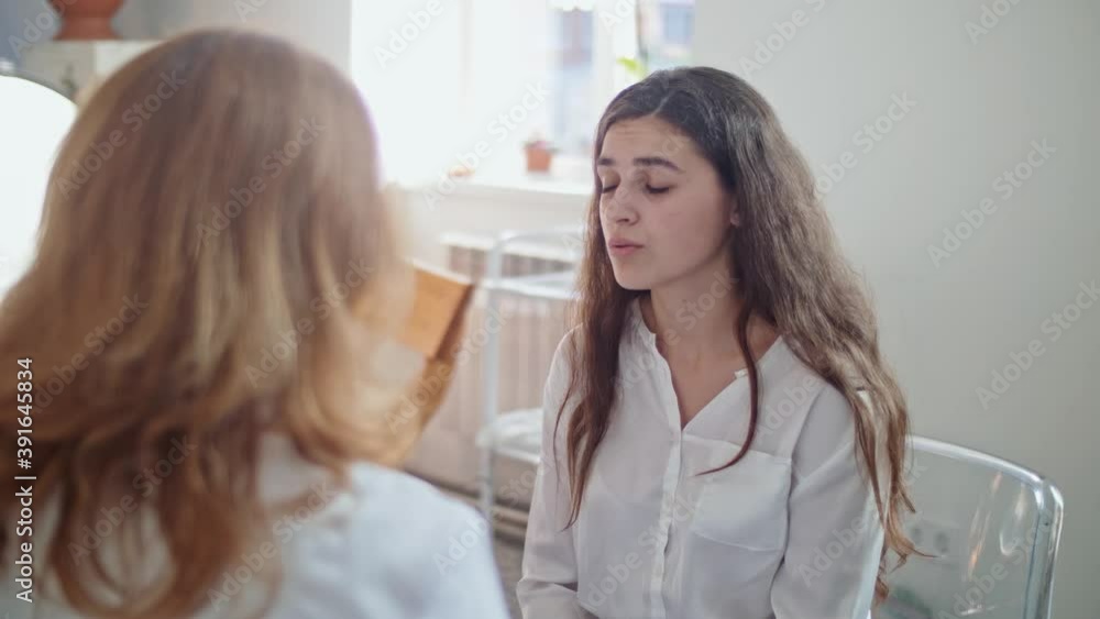 Sad Woman is Visiting a Doctor at Clinic. Female Doctor Examining and Consulting Ill Woman in the Hospital. Consulting of Patient at Clinic. Medical Professionals at Work. Sad Woman is Visiting a Doctor at Clinic. Female Doctor Examining and Consulting Ill Woman in the Hospital. Consulting of Patient at Clinic. Medical Professionals at Work.