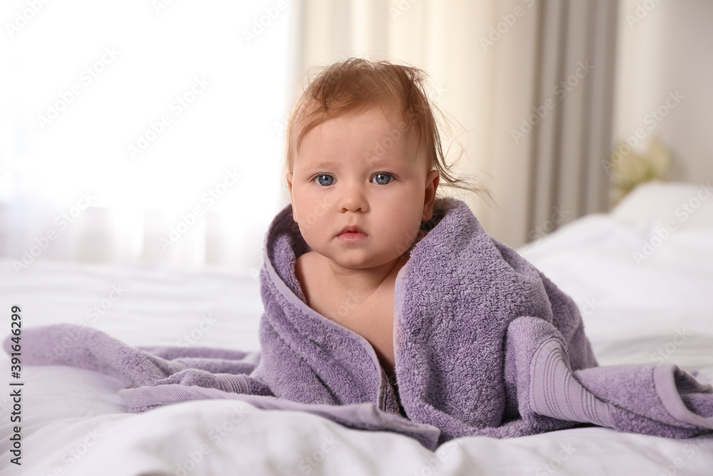 Cute little baby with soft purple towel on bed after bath Cute little baby with soft purple towel on bed after bath
