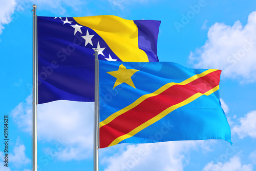 Congo and Bosnia Herzegovina national flag waving in the windy deep blue sky. Diplomacy and international relations concept.