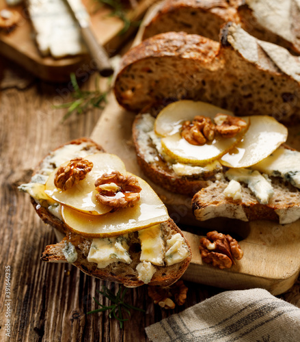 Sourdough bread sandwich with gorgonzola cheese, walnuts and honey close up view