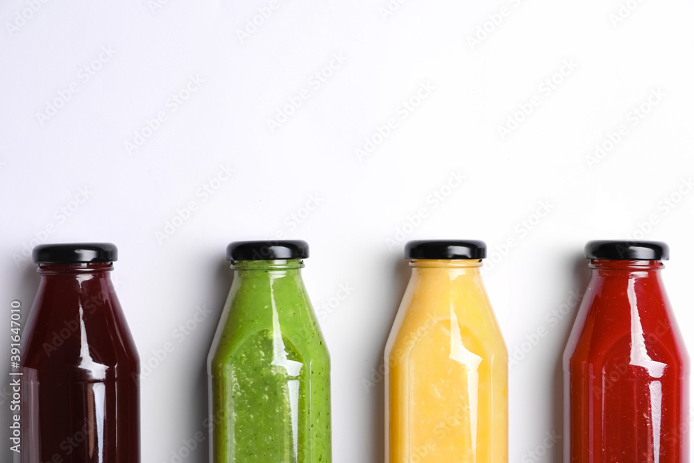 Bottles with delicious colorful juices on white background, flat lay Bottles with delicious colorful juices on white background, flat lay
