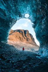 Solo female adventure traveler is discovering the ice caves in Iceland at Vatnajokull Glacier near to Jokulsarlon Glacier Lagoon. Tourism in abandoned Iceland . Outdoor living and exploring 