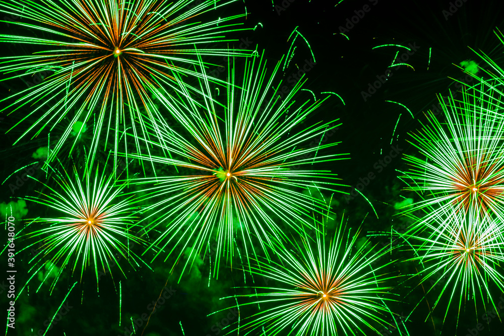 Vivid fireworks with sparks in green colors. Explosive pyrotechnic devices for aesthetic and entertainment purposes. Holiday background