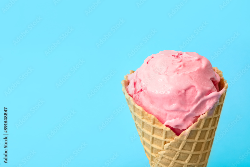 Delicious pink ice cream in waffle cone on light blue background, closeup. Space for text Delicious pink ice cream in waffle cone on light blue background, closeup. Space for text