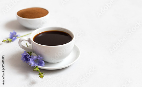 Cup with chicory drink and chicory powder on a white background. Healthy beverage. Coffee substitute.