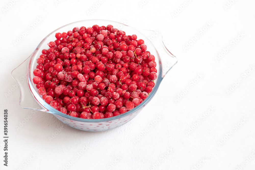 Frozen red currant on a white background. Red frozen berries in a bowl. Healthy diet. Space for text. Frozen red currant on a white background. Red frozen berries in a bowl. Healthy diet. Space for text.
