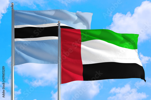 United Arab Emirates and Botswana national flag waving in the windy deep blue sky. Diplomacy and international relations concept.