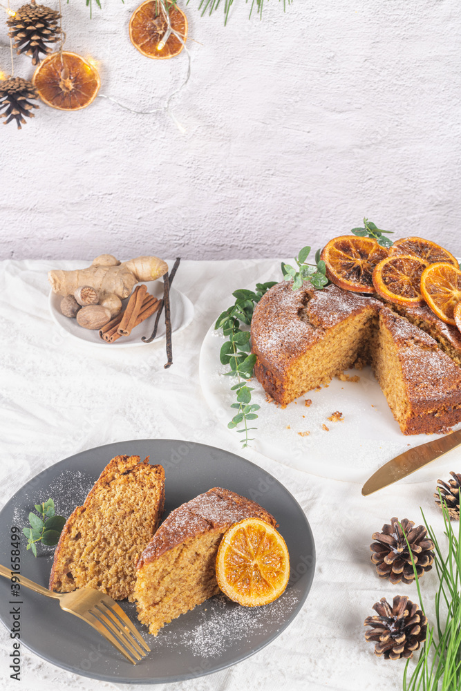 Christmas orange and spice cake. Decorated with dried oranges on kitchen countertop
