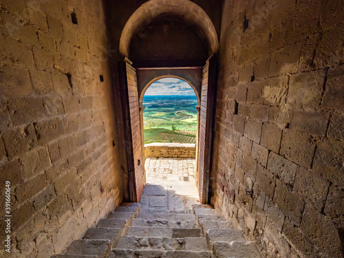 Amazing shot of a stone made historic building door opening with a picturesque landscape view photo