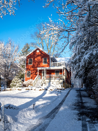 red suburban house covered with snow in winter photo