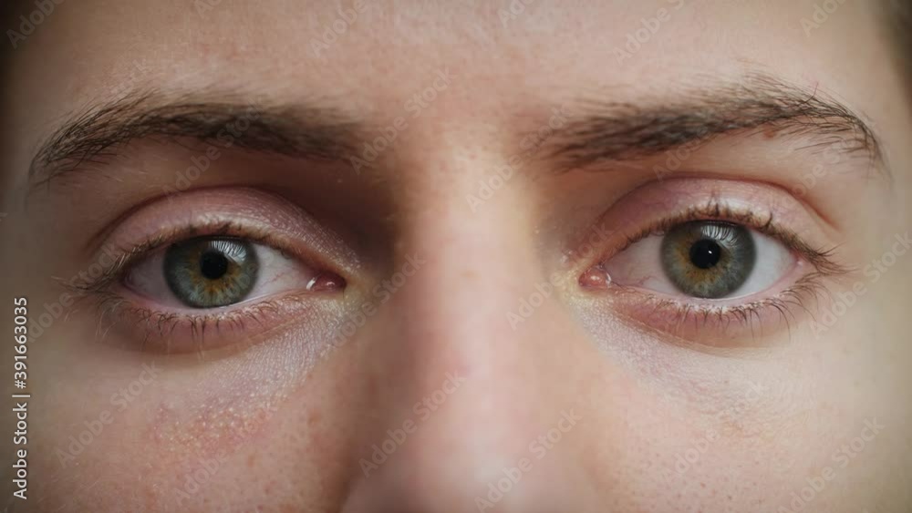 Close up of Man's face. Attractive boy opening his beautiful blue eyes. Caucasian young male model with blue, green, grey eyes looking at camera. Slow-motion, macro extreme close-up, 4K. Close up of Man's face. Attractive boy opening his beautiful blue eyes. Caucasian young male model with blue, green, grey eyes looking at camera. Slow-motion, macro extreme close-up, 4K.
