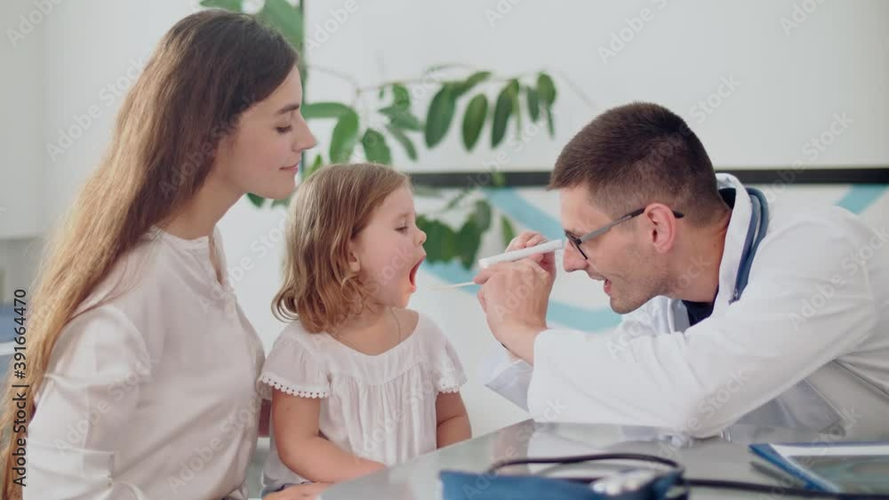 Male Doctor Pediatrician Examining an Ill Sad Kid at Medical Visit With Mother in the Hospital.Male Family Doctor Examining Ill Child.Talking With Doctor at Consultation During an Appointment Male Doctor Pediatrician Examining an Ill Sad Kid at Medical Visit With Mother in the Hospital.Male Family Doctor Examining Ill Child.Talking With Doctor at Consultation During an Appointment