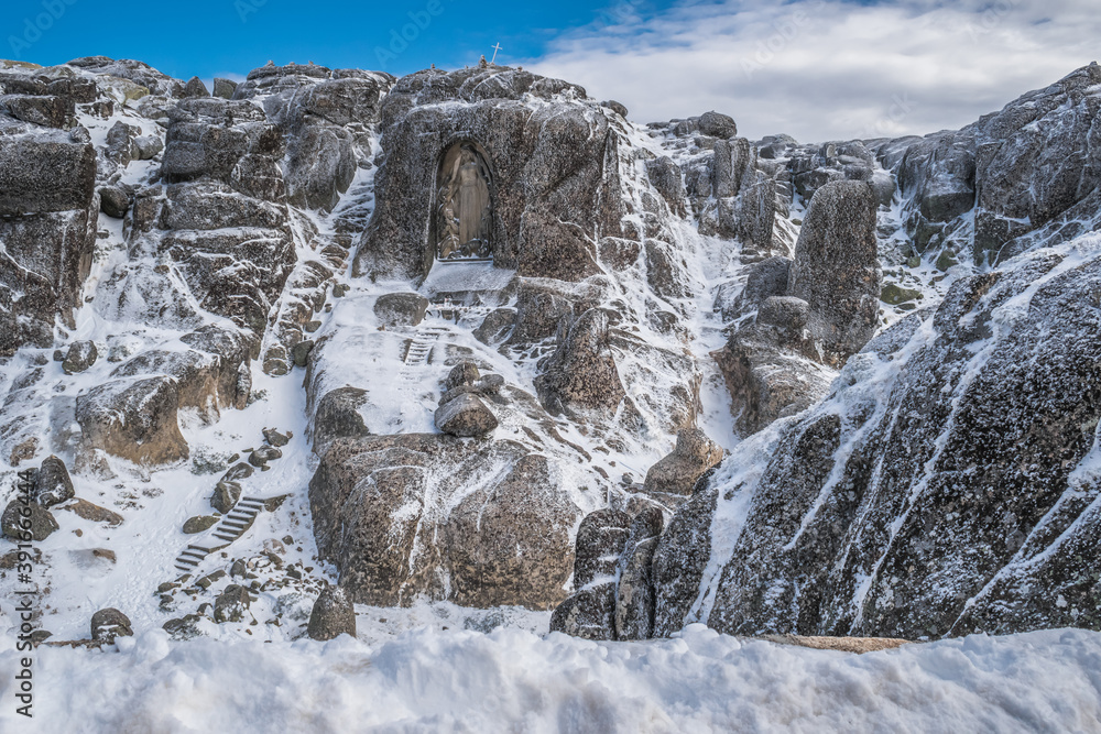 Our Lady of Boa Estrela carved in granite stone in snowy mountain, Serra da Estrela Natural Park PORTUGAL