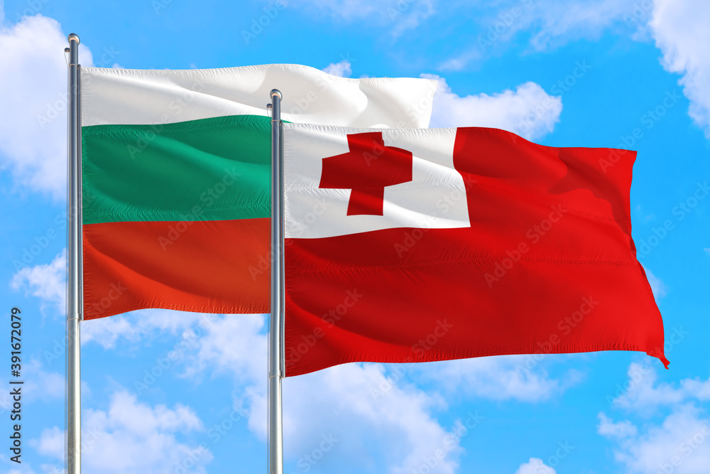 Tonga and Bulgaria national flag waving in the windy deep blue sky. Diplomacy and international relations concept.