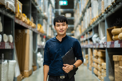 man worker holding clipboard and checking inventory in the warehouse store