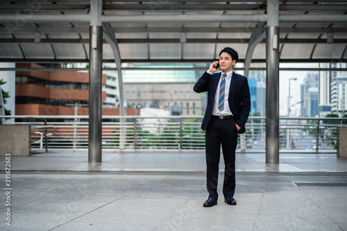 successful business man in suit talking a mobile phone in city