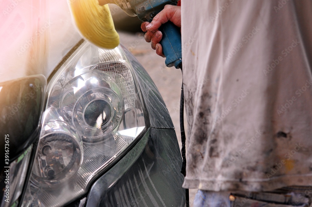 Big headlight cleaning on the car with power buffer machine at service station,Before and after