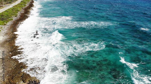 Blue sea wave crashing against rocky stone cliff © DELVIT