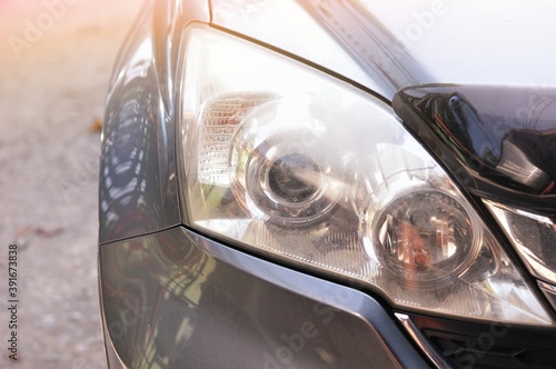 Big headlight cleaning on the car with power buffer machine at service station,Before and after cleaning car concept with a mechanic cleaning the headlights of a car using a power buffer machine