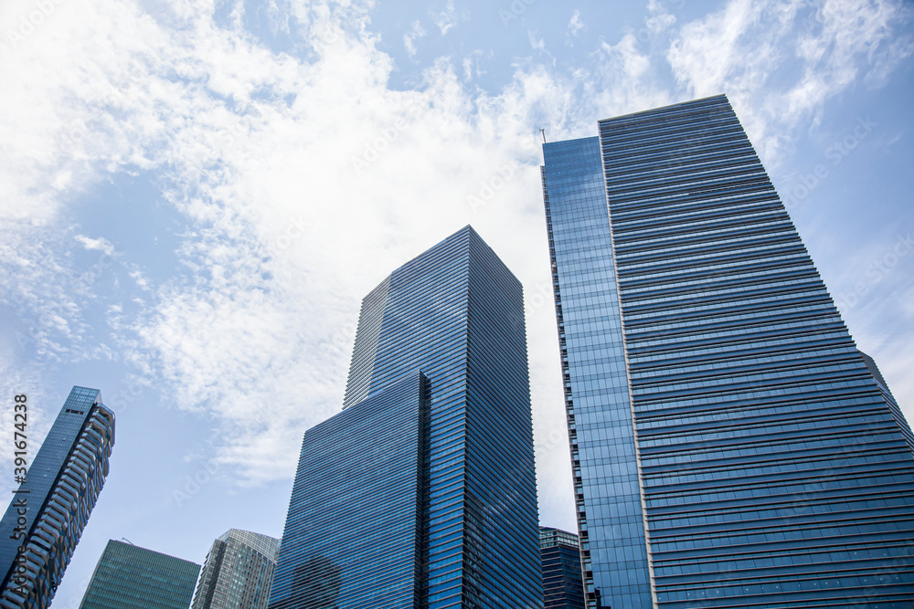 office building in the city. Looking Up At Modern Corporate Buildings On A Sunny Day, With Dramatic Clouds, In Singapore. Stock Photo..