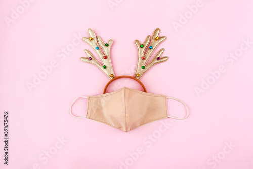 Festive christmas reindeer made from face mask, decorations.Creative minimal concept of Christmas and New Year during the pandemic covid-19 and stay at home quarantine.Flat lay, top view, copy space.