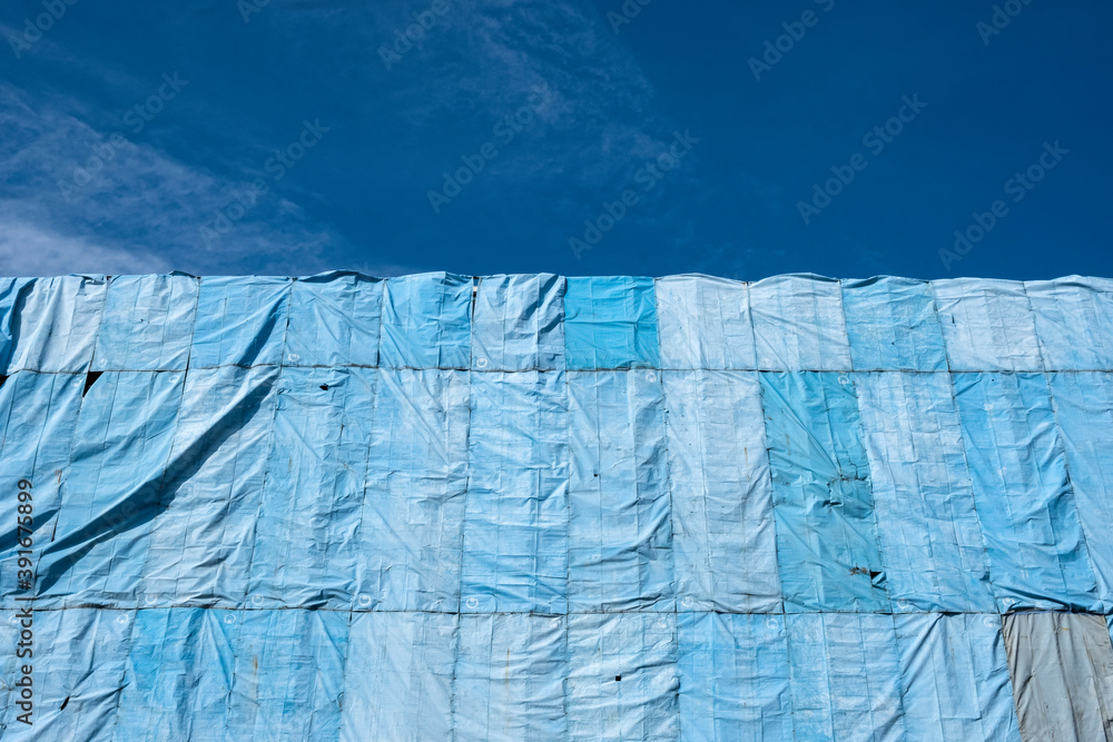 Abstract Detail Of Blue Tarpaulins With Dappled Sunlight, On A