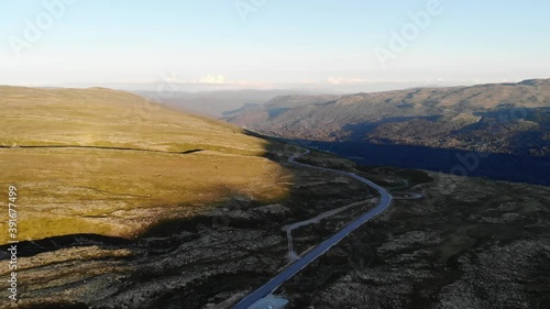 A mountain road leading towards a valley. Southern Norway. Drone footage photo