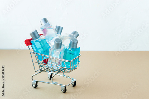 lots of small jars of clear and blue gel in miniature metal grocery cart with red handle, selective focus