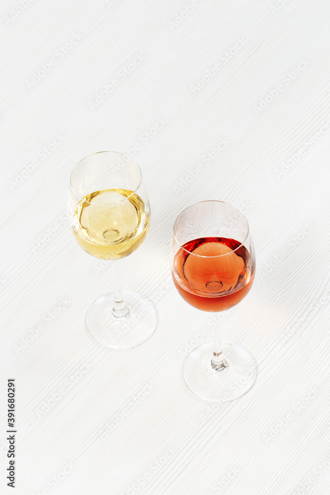 Rose and white wine in glass on light wooden table