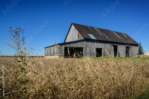 Old wooden plank barn for storing tractors and farm equipment