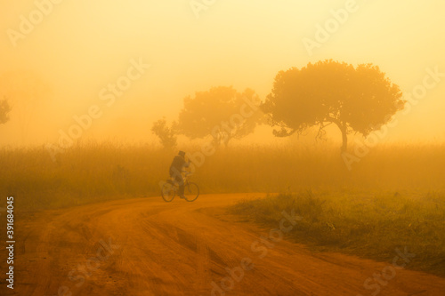 Man ride on bicycle in winter misty morning. 