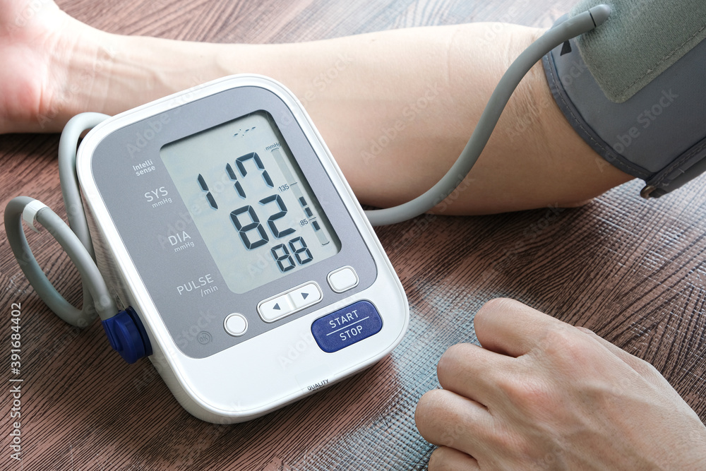 Man check blood pressure monitor and heart rate monitor with digital pressure gauge. Health care and Medical concept Man check blood pressure monitor and heart rate monitor with digital pressure gauge. Health care and Medical concept