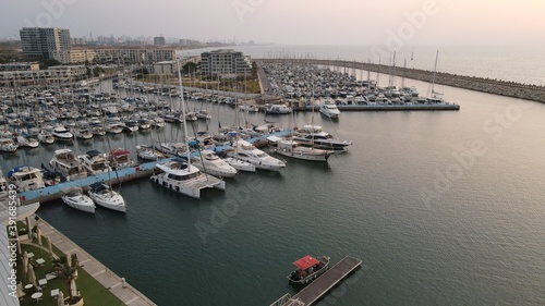 group of boats are moored together at a small marina in the Herzliya Marina. © pavlovski